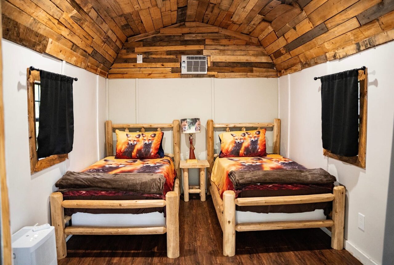 Cabin interior with two twin log beds at Brawler Creek Ranch