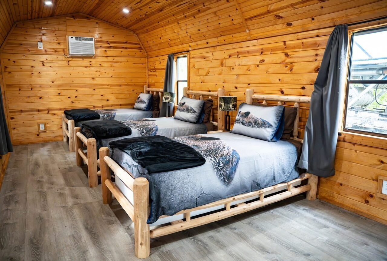 Cedar-walled cabin interior with log beds at Brawler Creek Ranch