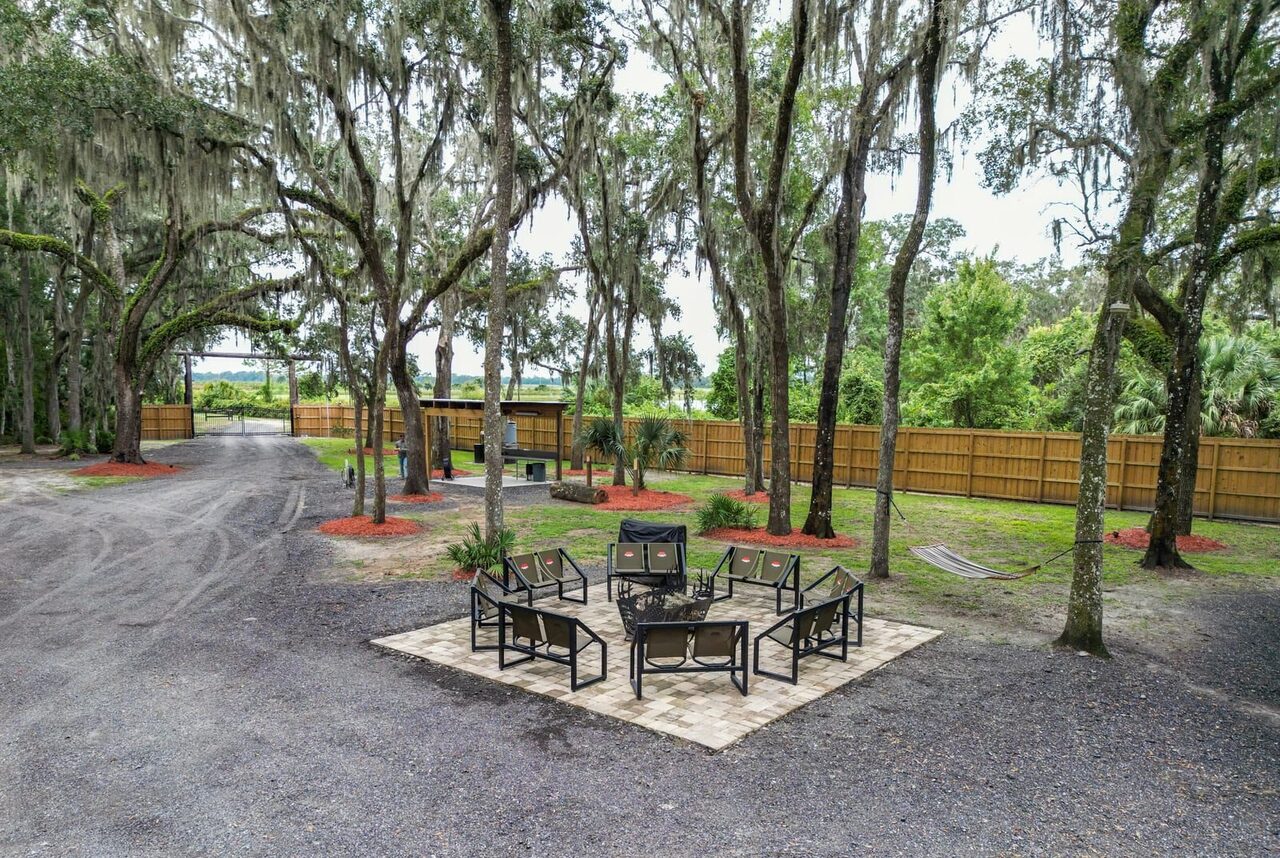 Fire pit seating circle under the oaks at Brawler Creek Ranch hog hunting retreat
