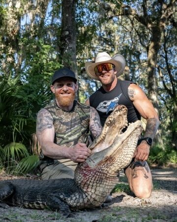 Two hunters kneeling with a trophy alligator at Brawler Creek Ranch